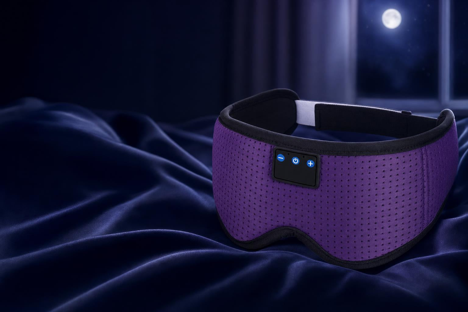 Bluetooth sleep mask resting on navy silk at night
